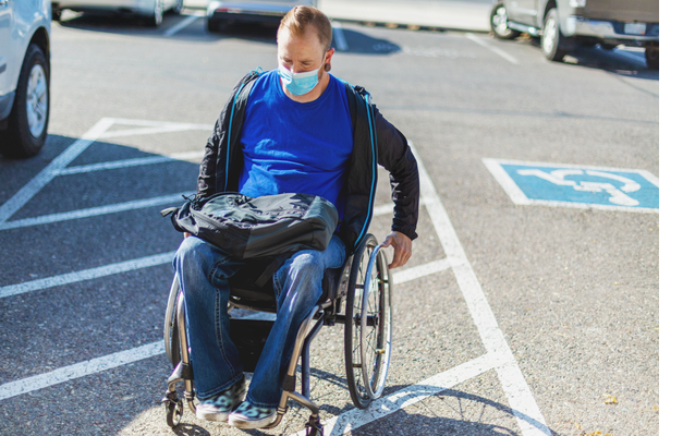 Individual using wheelchair in parking lot