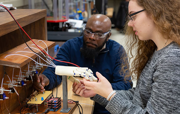 A Student and Advisor Working with Equipment.